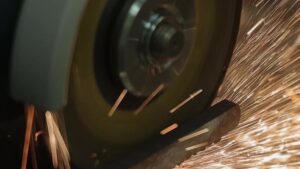 meuleuse en action coupant une barre métallique