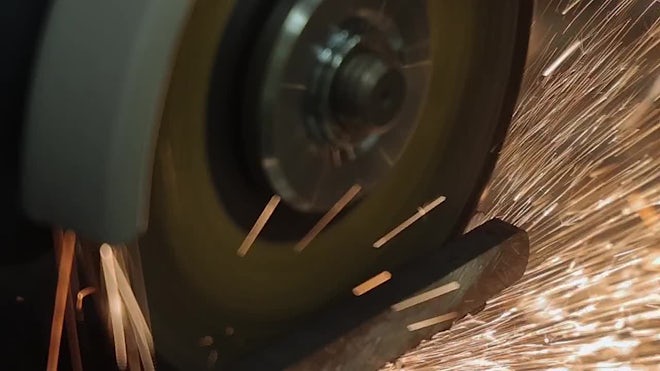 meuleuse en action coupant une barre métallique